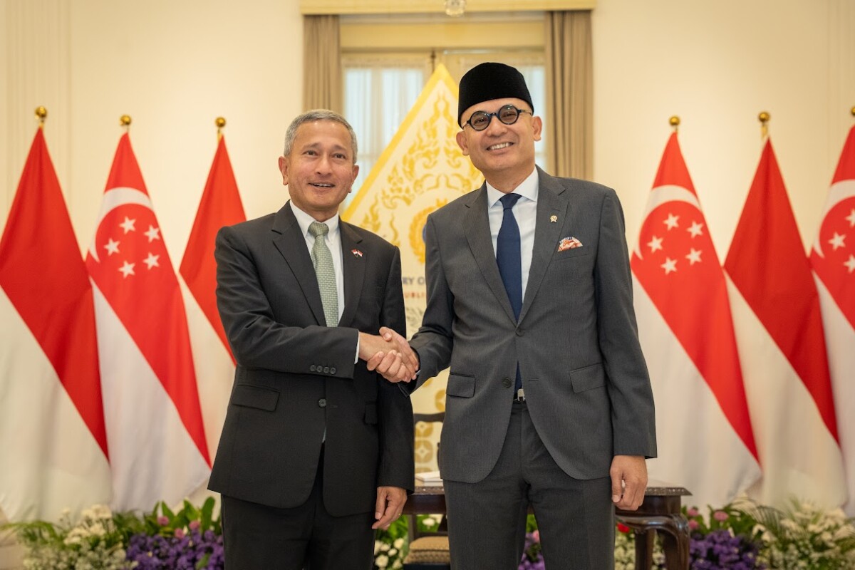 Dr Vivian Balakrishnan shakes hands with Indonesian Foreign Minister Arrmanatha Nasir in front of national flags