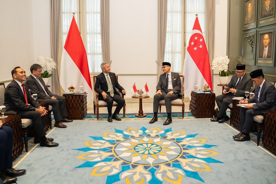 Singapore and Indonesian delegations seated facing each other in a meeting room in Jakarta