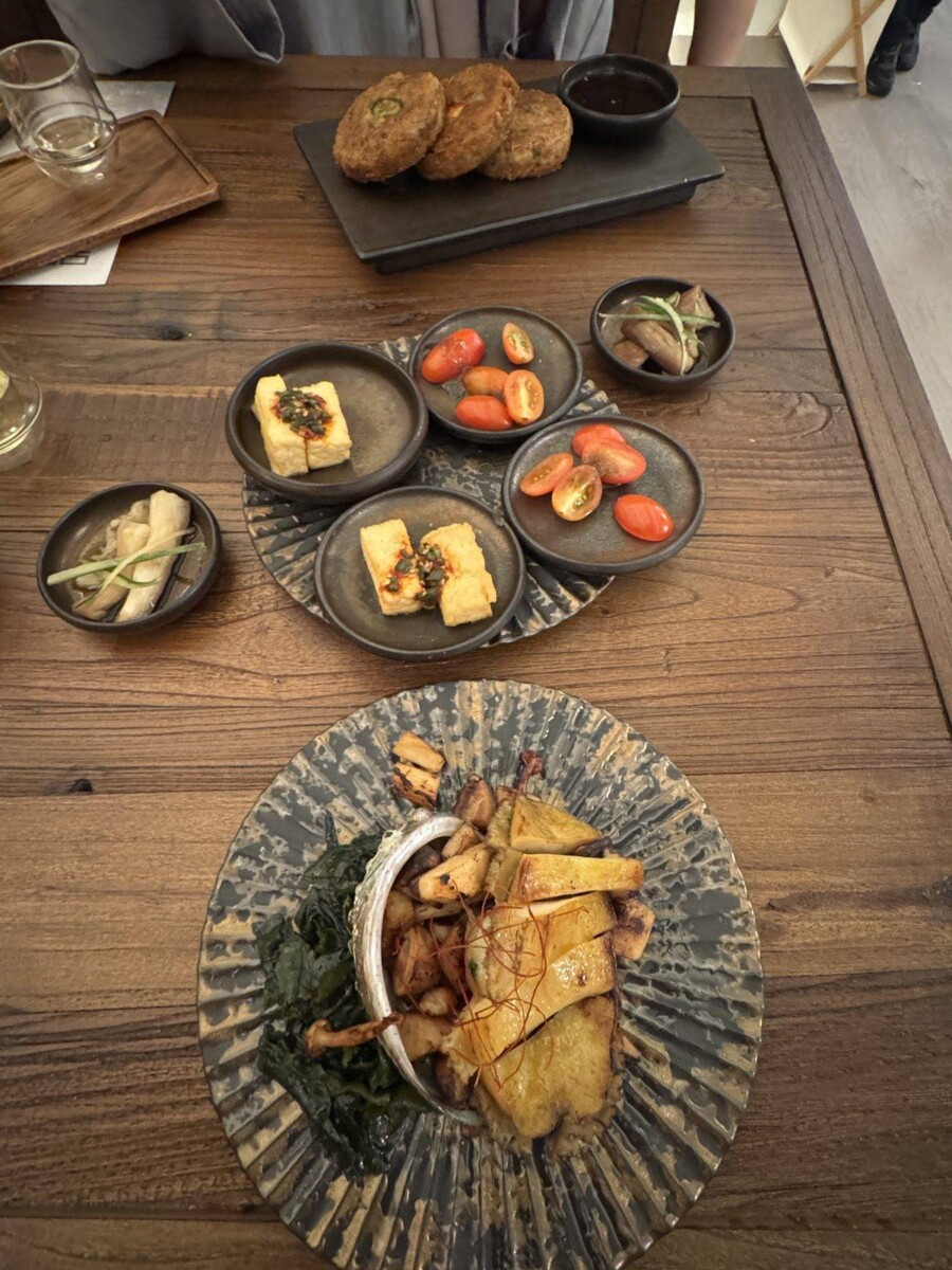 Shareable spread at MODU Samgyetang including appetisers, mung bean pancake, and a Black Chicken Samgyetang clay pot