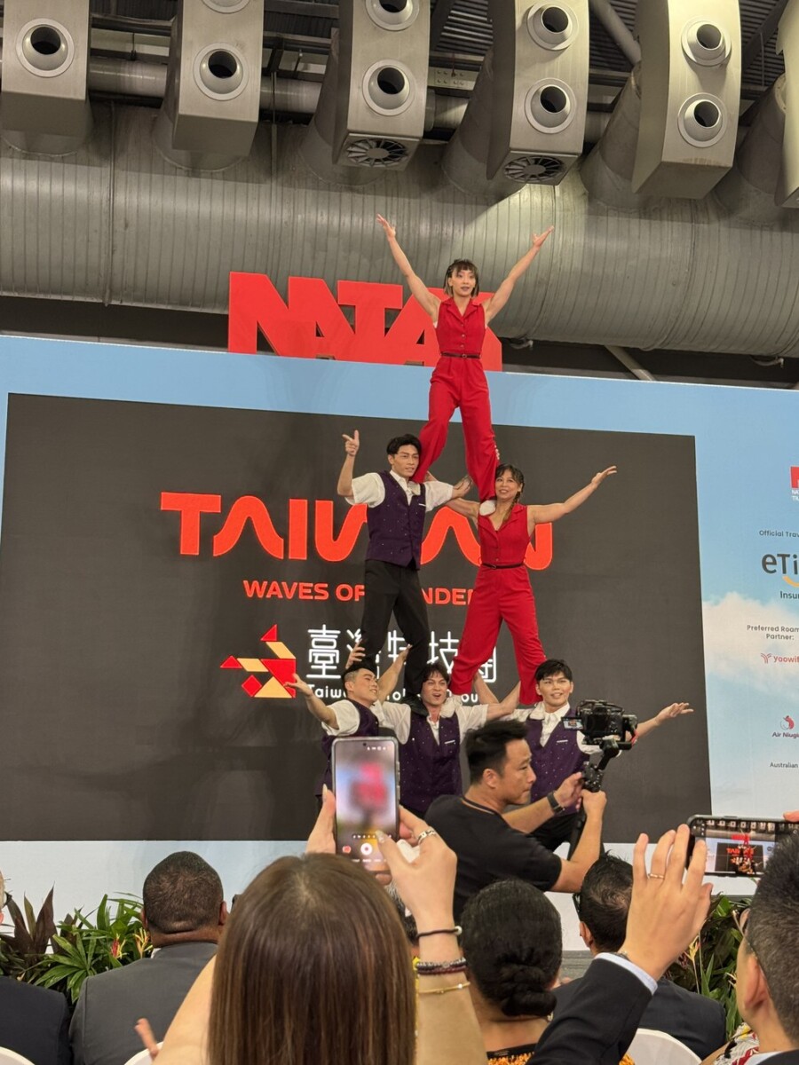 Taiwan Acrobatic Troupe posed together in front of a Taiwan Waves Of backdrop after their performance