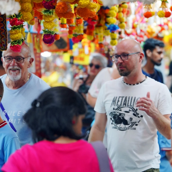 Shoppers walk past garland stalls in Little India during the Deepavali season