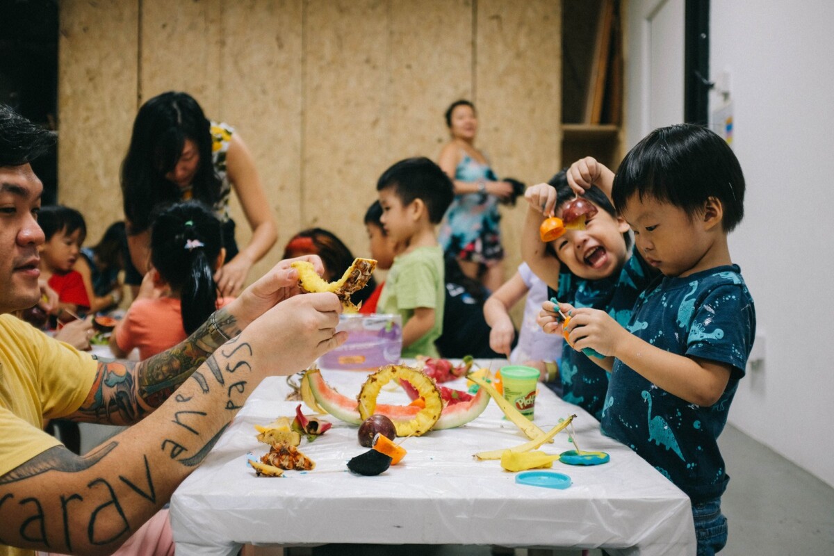 Children and adults playing with fruit and play dough at a Playeum session