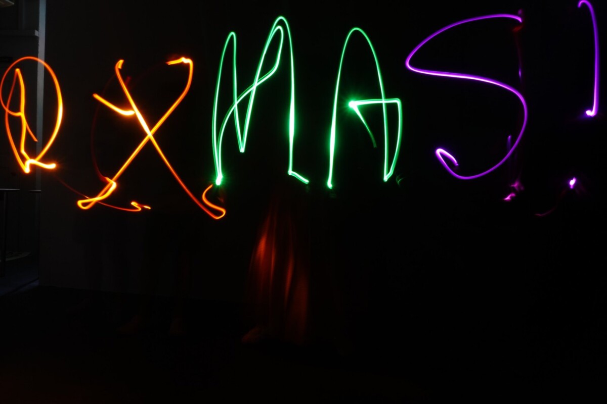 Long-exposure light painting spelling XMAS in coloured light trails at Objectifs