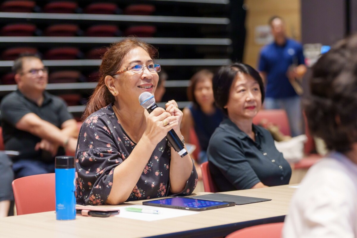 Resident holding a microphone at an AI travel planning course at Geylang Serai Community Club