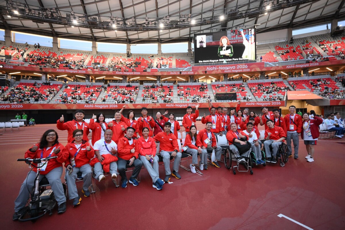 Team Singapore para athletes and officials posing together in a stadium
