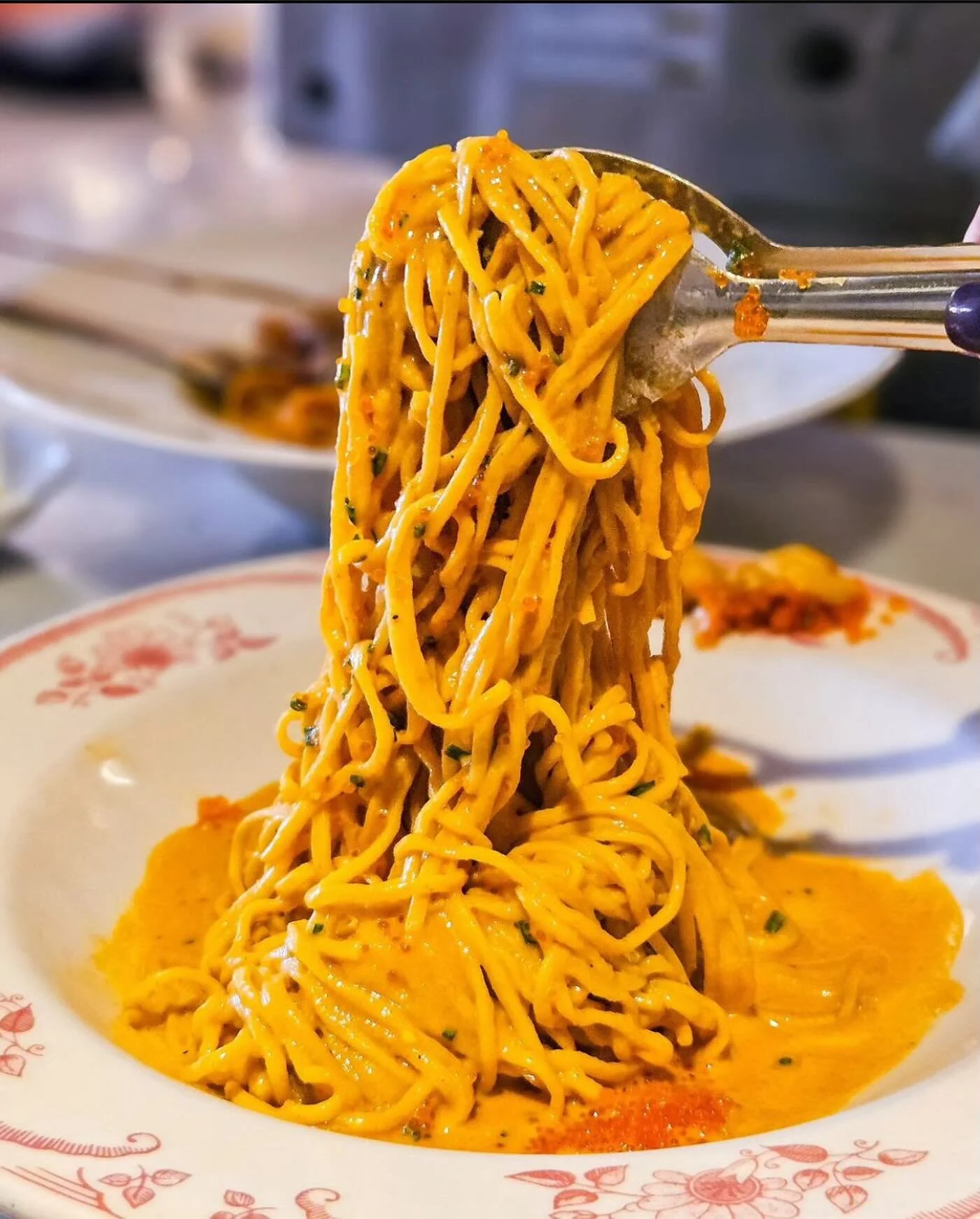 Fork twirling fresh spaghetti in a creamy orange sauce at Pasta Bar