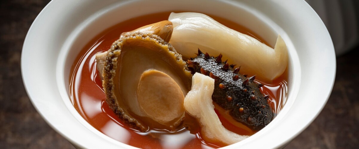 Bowl of bak kut teh broth with abalone, sea cucumber and fish maw