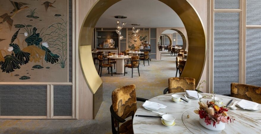 Peach Blossoms dining room with a round brass archway and round tables