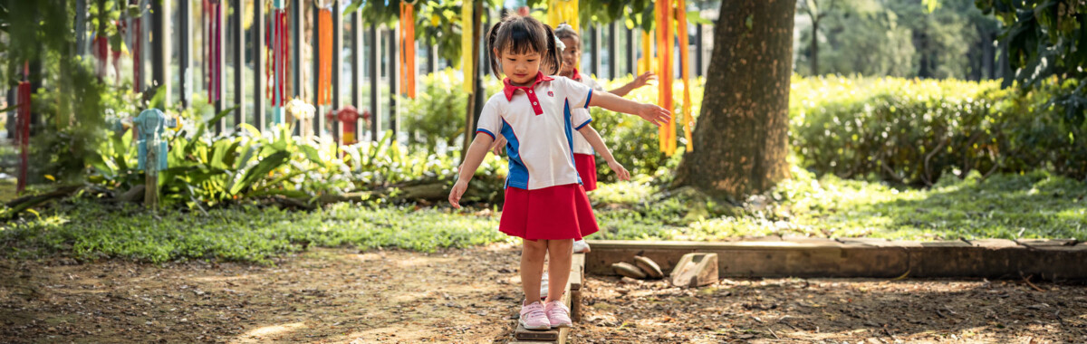 PCF Sparkletots children on an outdoor balance beam in preschool uniforms