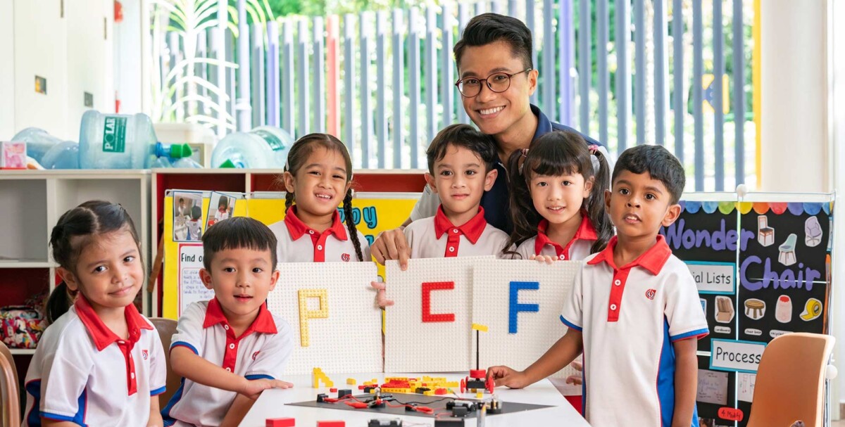 Preschool children and a teacher with building blocks in a PCF Sparkletots classroom