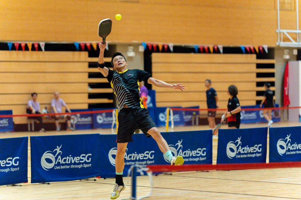 Pickleball player returning a shot during the Pesta Sukan Community Championship