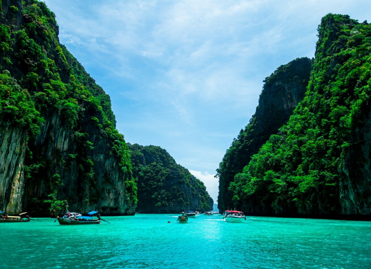 Longtail boats on turquoise water between limestone karsts of the Phi Phi Islands