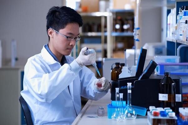 Laboratory officer pipetting a water sample at a PUB water quality lab
