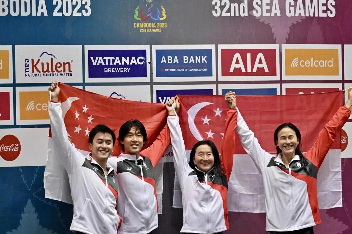 Quah Zheng Wen, Nicholas Mahabir, Quah Jing Wen and Quah Ting Wen with the Singapore flag after mixed medley relay gold at SEA Games 2023