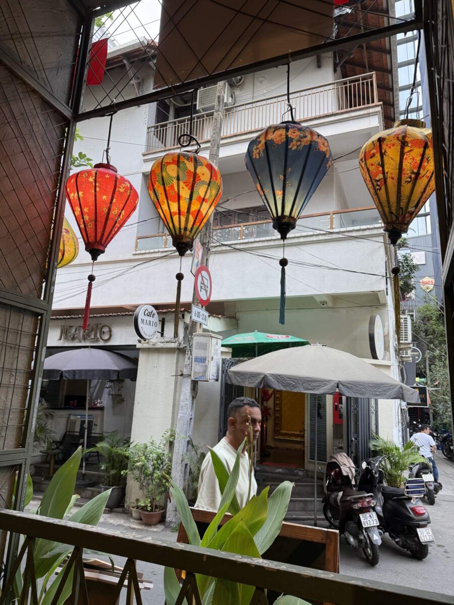 View from a table at Quan Bui Saigon facing colourful lanterns at the entrance and a small lane outside