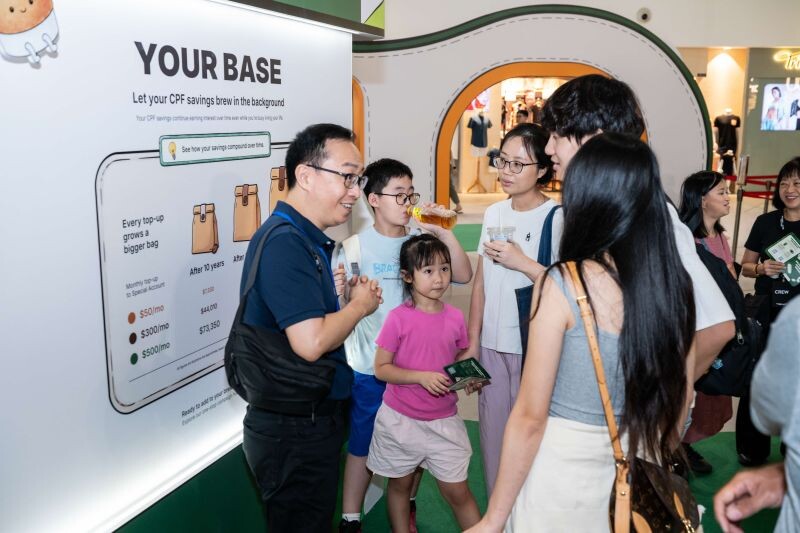 A CPF staff member explaining a CPF planning board to a family