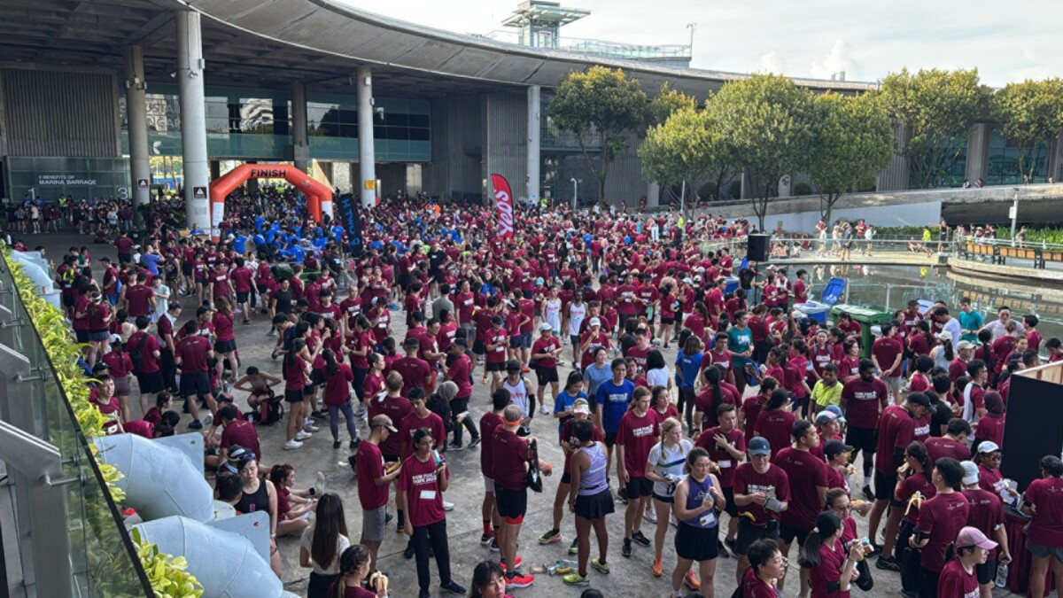 A crowd of Run For Hope 2024 runners in maroon shirts massed at Marina Barrage