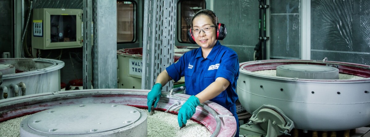 An SAESL technician in ear defenders and gloves at work in the Singapore repair shop