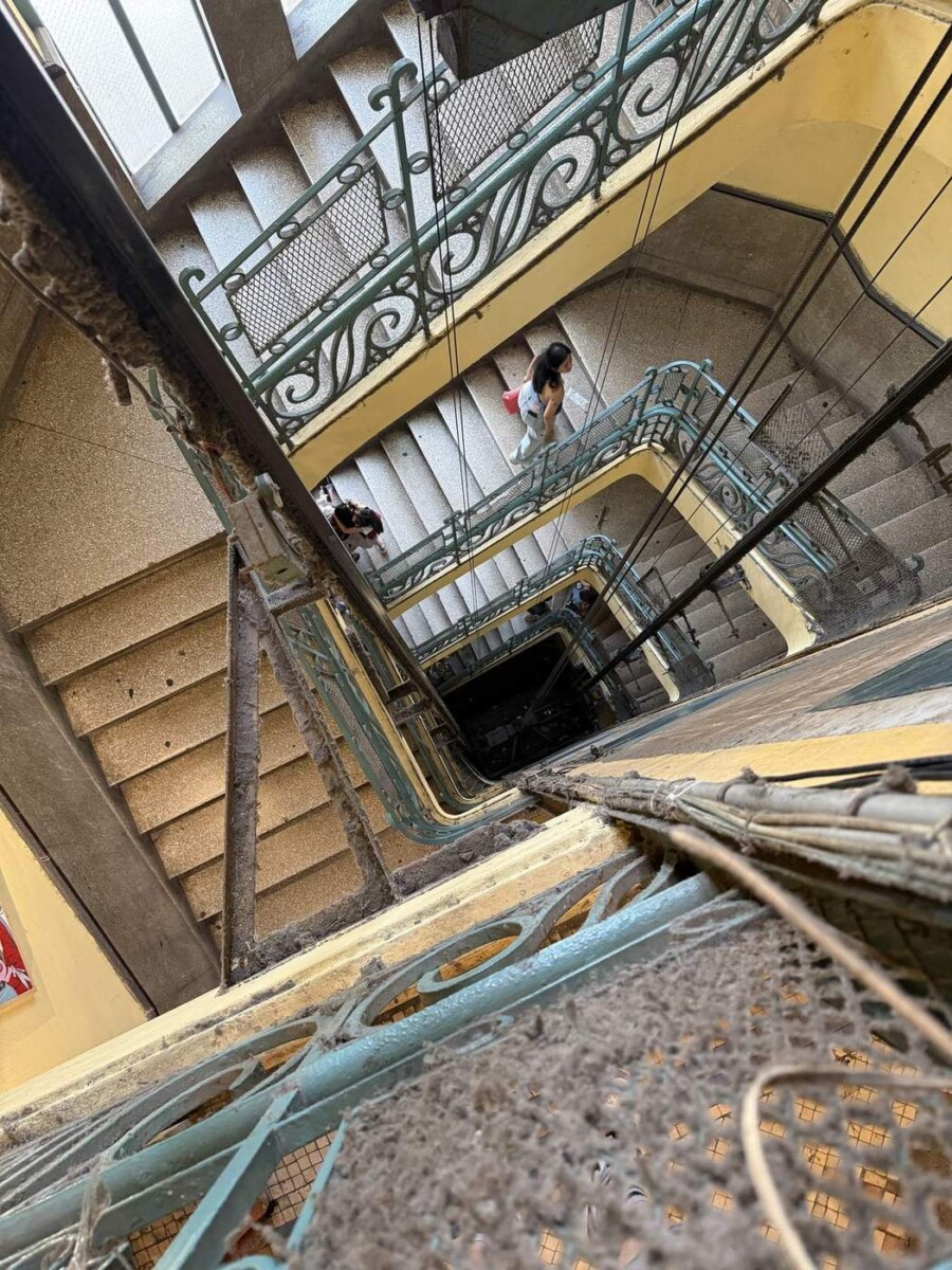 Looking down from the upper floors of 26 Ly Tu Trong, Saigon, with dust and patina on the staircase