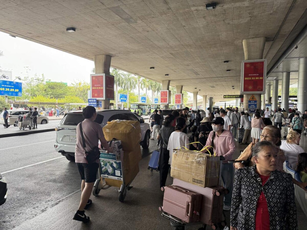 Busy pickup area outside Saigon airport with cars and people