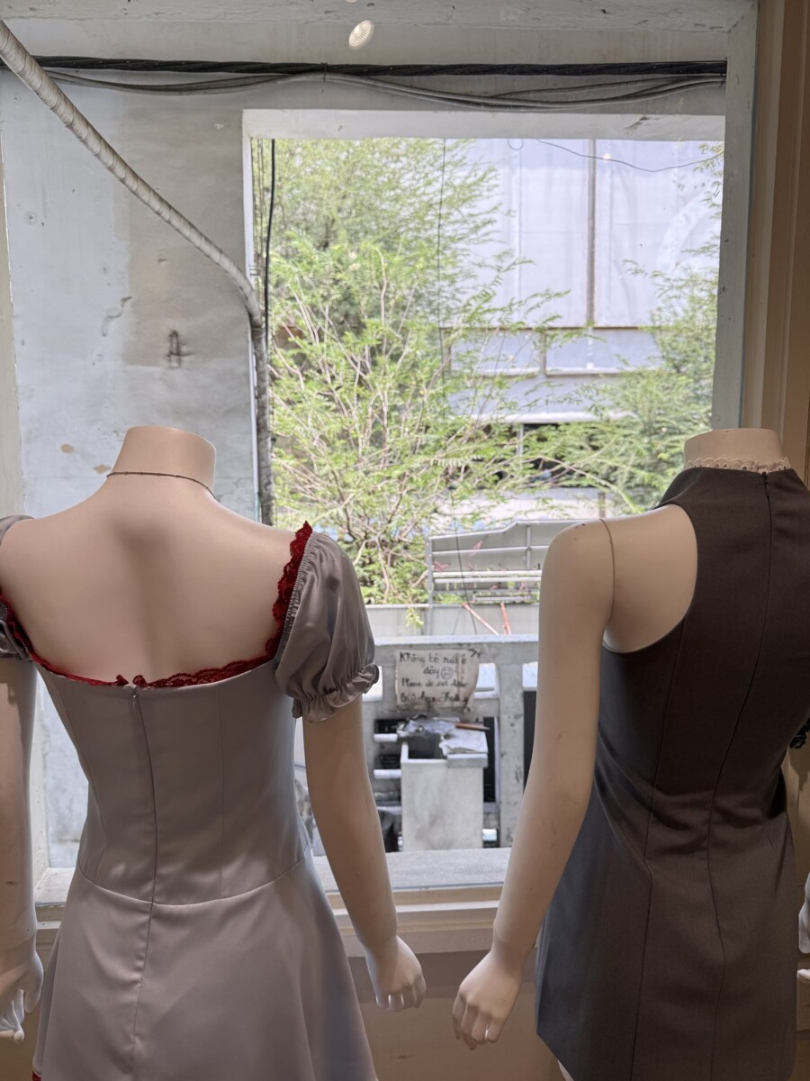 Boutique on the upper floor of an old Saigon shophouse, with mannequins by the window and exposed concrete and wiring