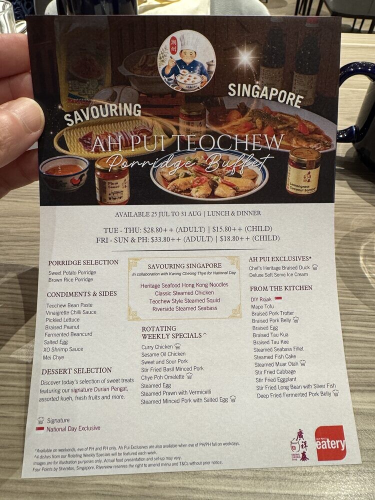 Hand holding the printed Savouring Singapore Ah Pui Teochew menu, listing porridge selections, condiments, sides and the National Day specials