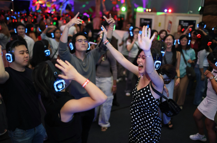 Visitors dancing with glowing headphones at Science Centre silent disco