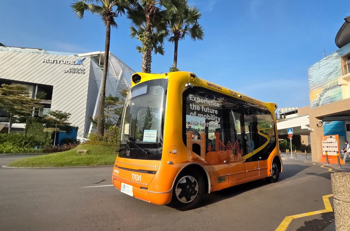 Front view of the yellow WeRide autonomous shuttle with TADA branding on a Sentosa road