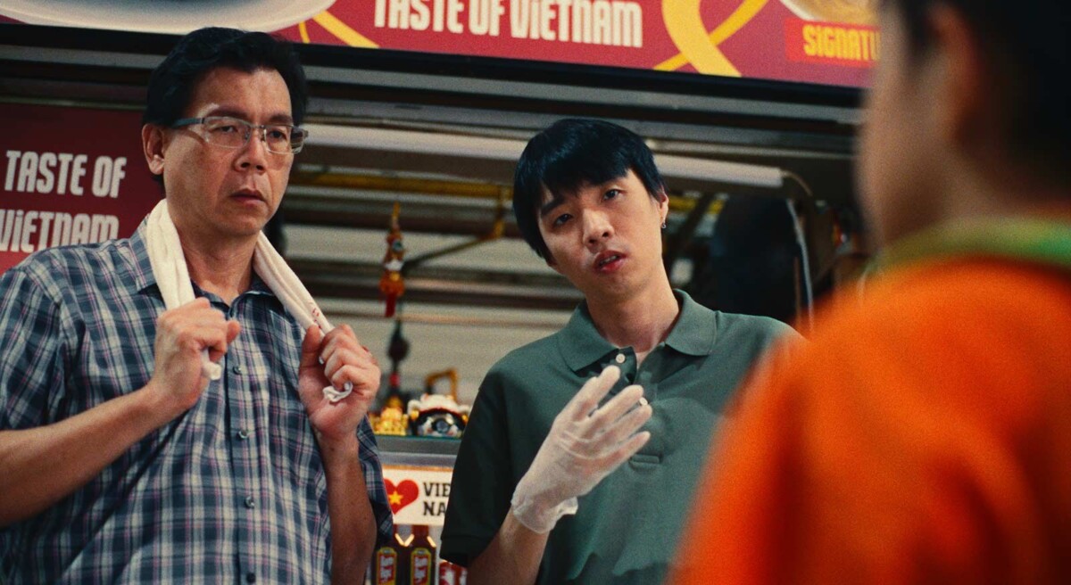 Father and son at a Taste of Vietnam hawker stall in a still from Son Of A