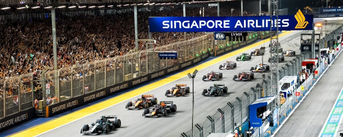 Formula 1 cars on the start straight of the Marina Bay Street Circuit at night