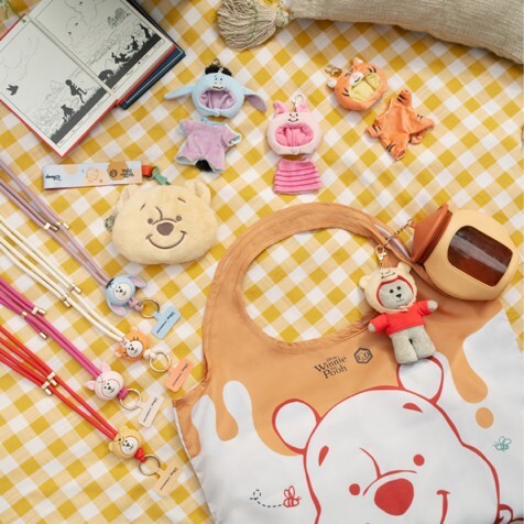 Starbucks Winnie the Pooh Bearista keychains, phone straps and reusable bag on a gingham cloth