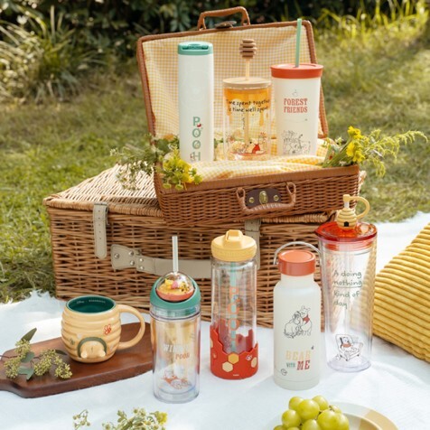 Starbucks Winnie the Pooh drinkware collection arranged on a picnic basket