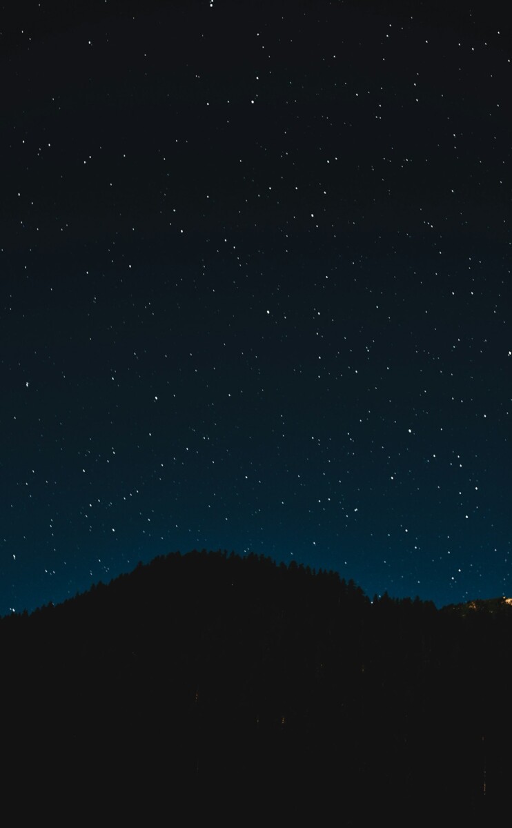 Starry night sky over a dark landscape away from city lights