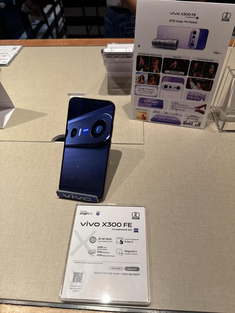 vivo X300 FE in Luxe Black on the display table with spec card at Swee Lee launch