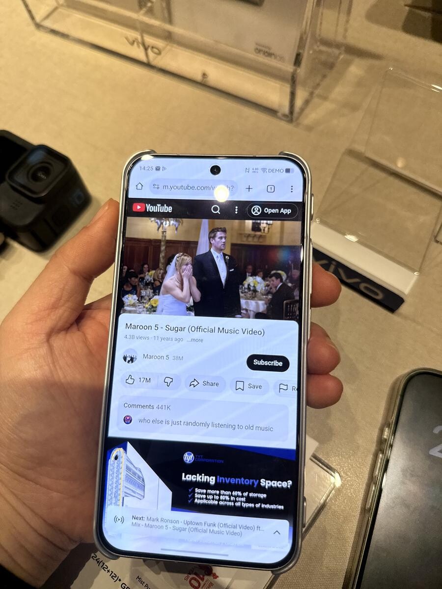Hand holding the vivo X300 FE showing the crisp 6.31-inch OriginOS display screen
