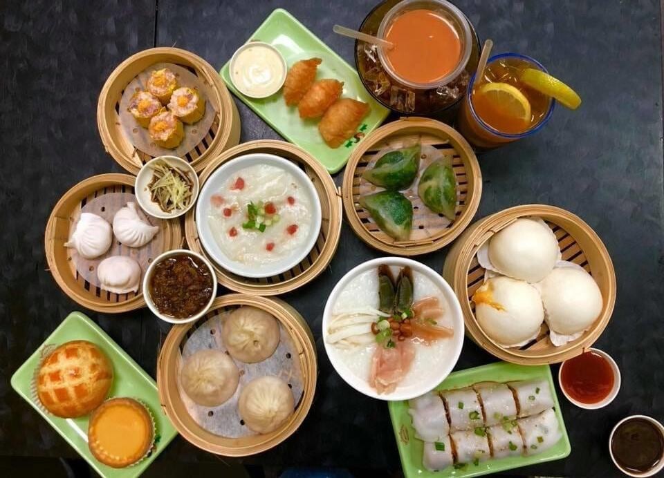 Bamboo steamers of dim sum with iced milk tea on a table