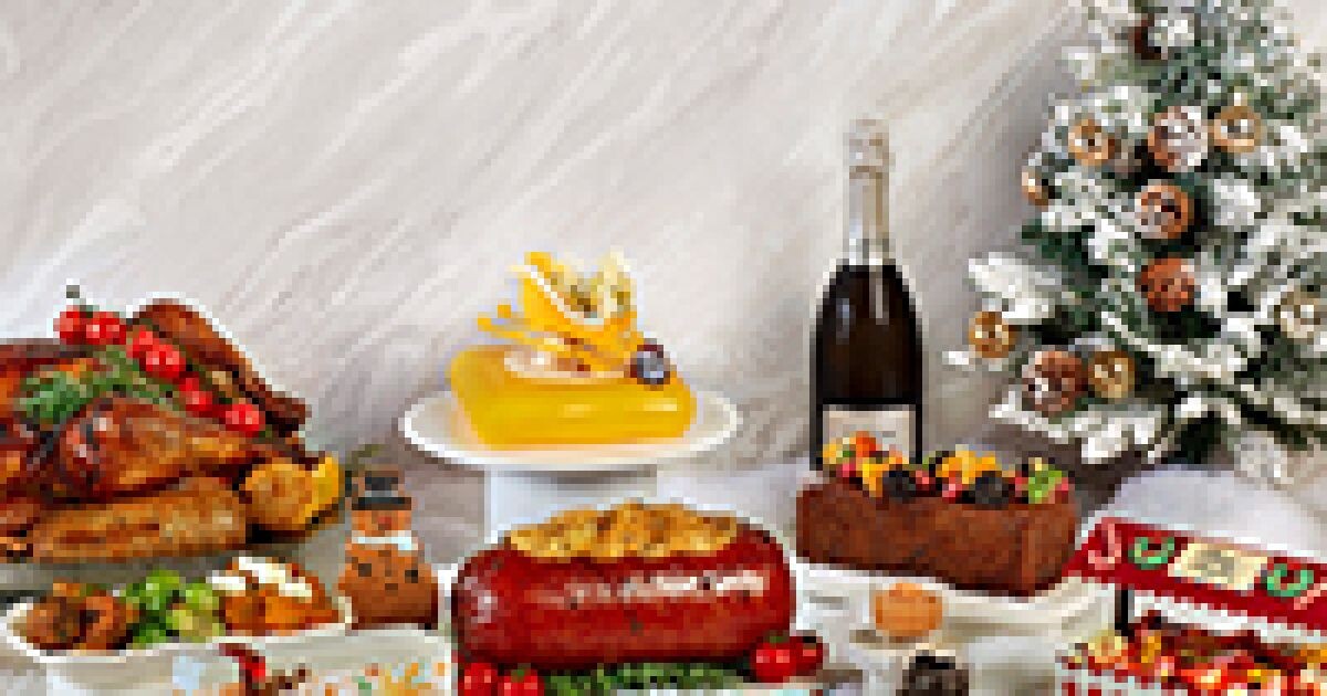 voco Orchard Singapore Christmas spread with roast meats, a log cake and festive bakes beside a Christmas tree